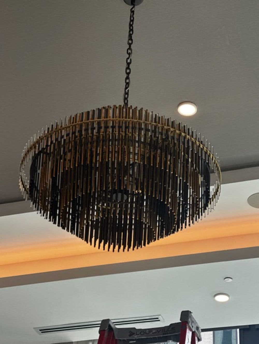 Modern chandelier with gold and black accents hanging from the ceiling in a stylish interior.